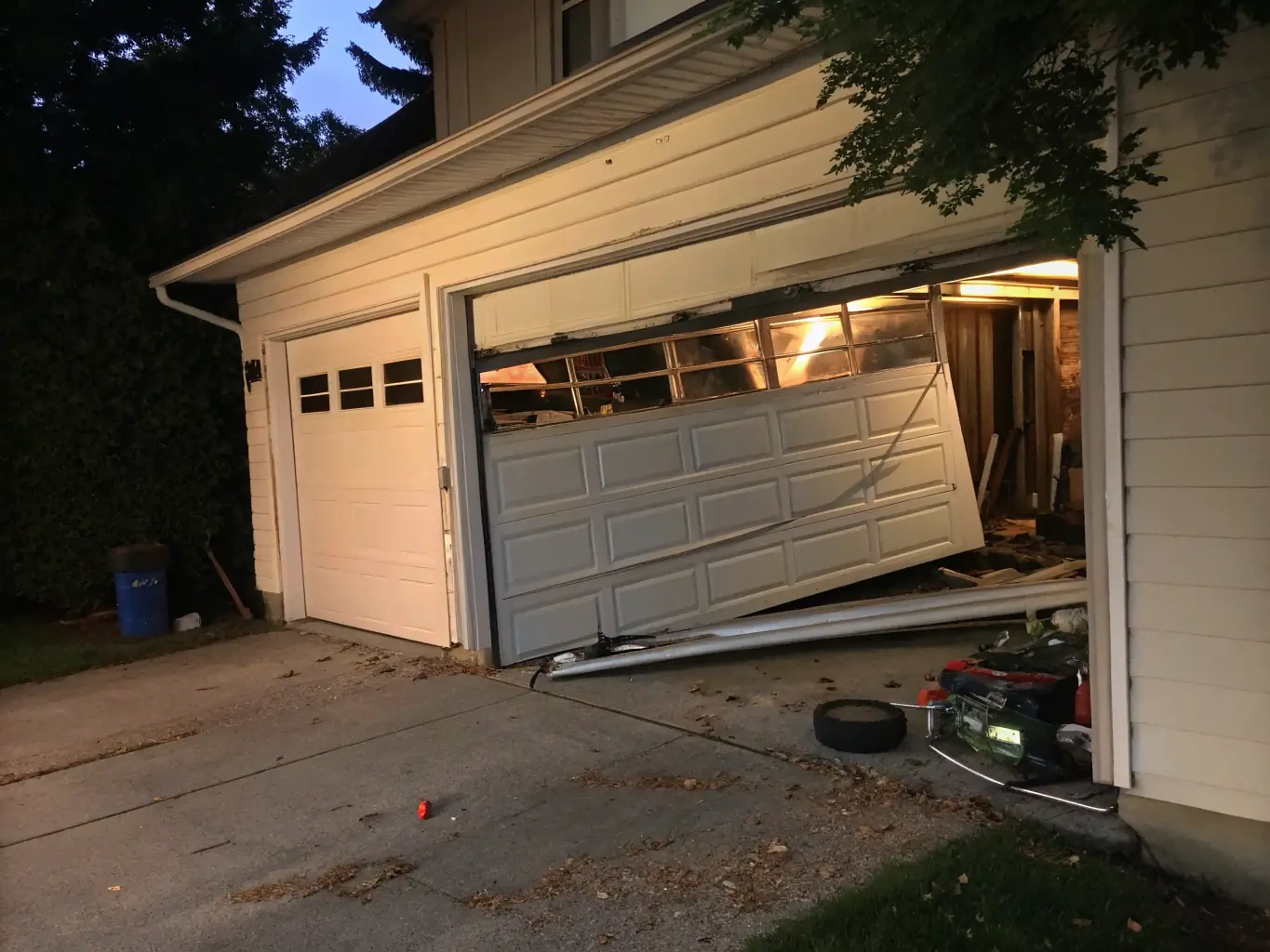 A garage door visibly off its tracks, tilted at an angle, with a concerned homeowner looking on and a Central Garage Doors van in the background.